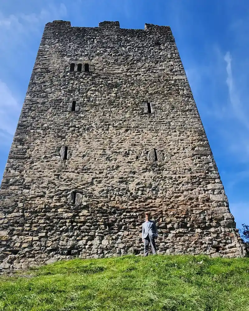 Jonas Trulli steht vor der Ruine Wartau, im Hintergrund der Turm